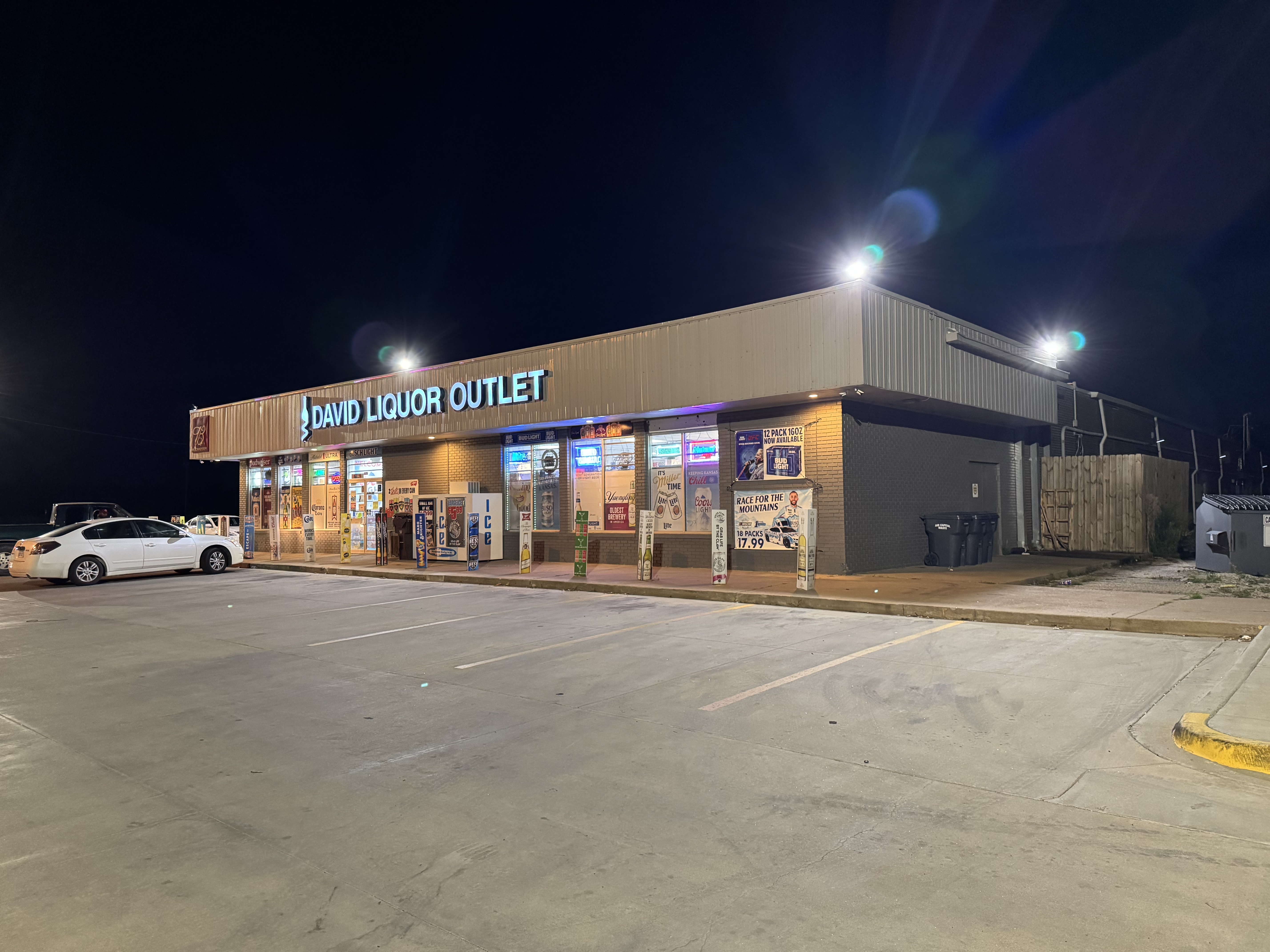 Night view of the David Liquor Outlet storefront and parking area